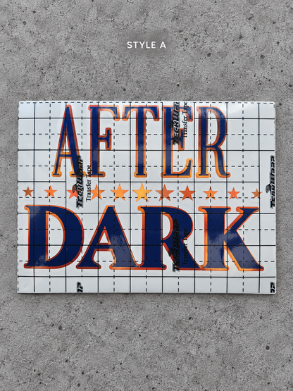 After Dark Style A vinyl decal with Cayenne Orange outline and Glossy Blue lettering under transfer tape on grey concrete
