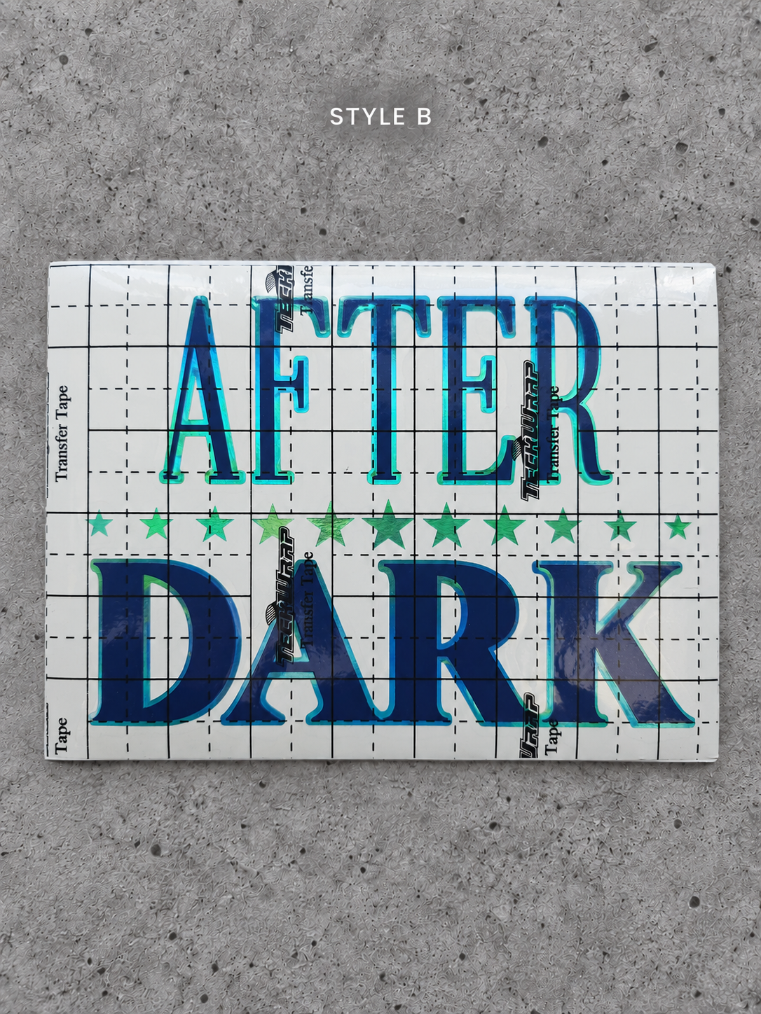After Dark Style B vinyl decal with Lime Green outline and Glossy Blue lettering under transfer tape on grey concrete