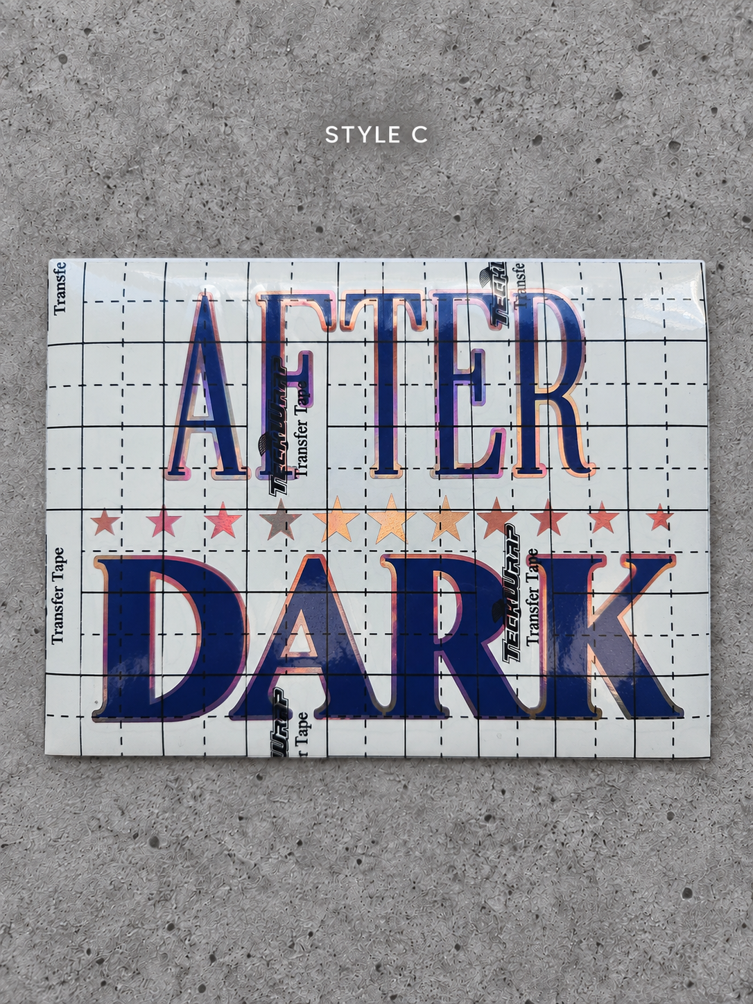 After Dark Style C vinyl decal with Rose Gold outline and Glossy Blue lettering under transfer tape on grey concrete
