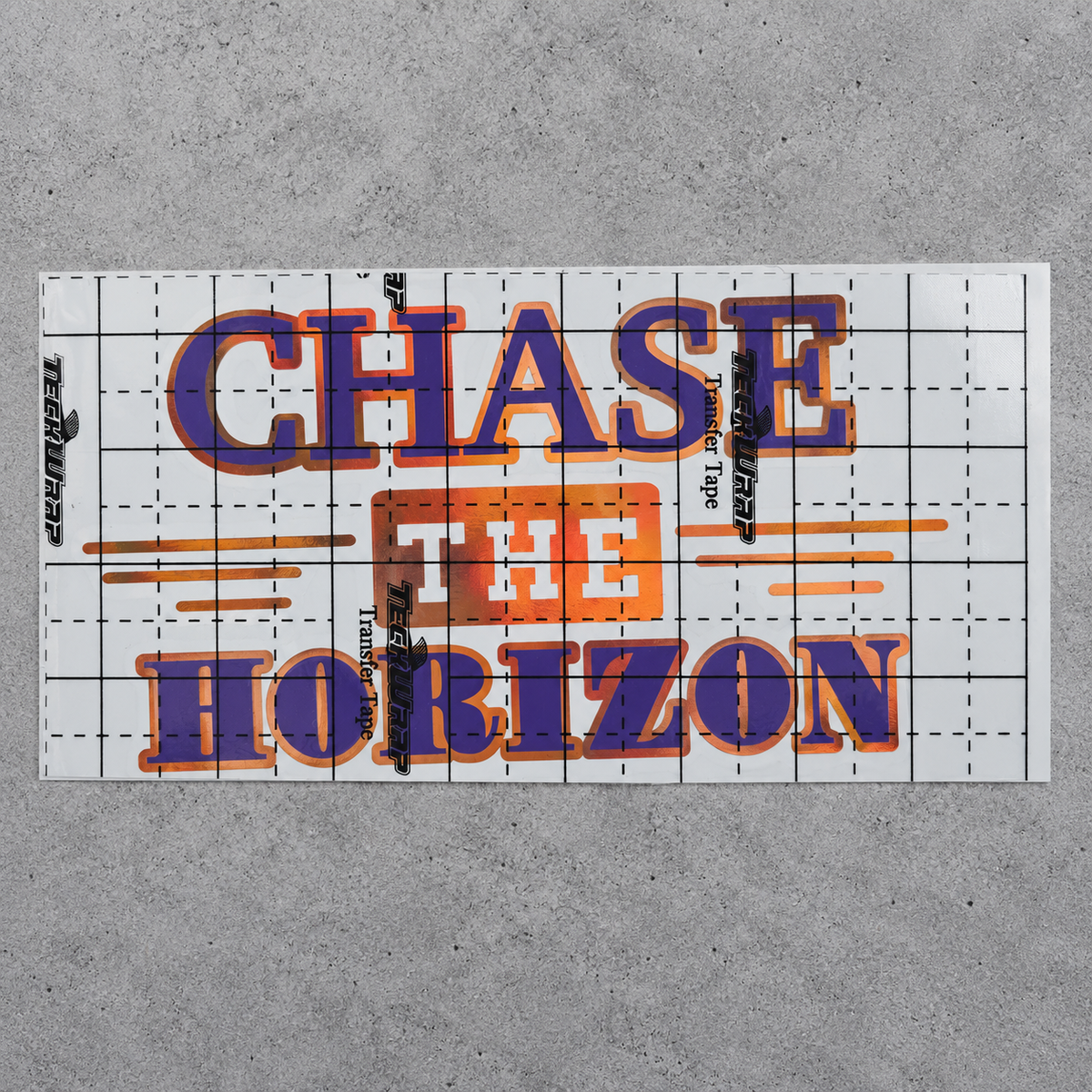 Chase the Horizon purple and orange vinyl decal under gridded transfer tape on grey concrete