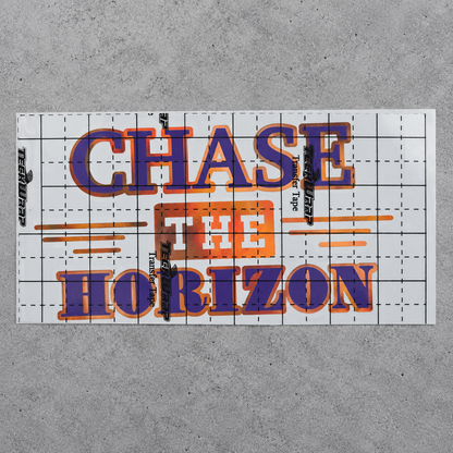 Chase the Horizon purple and orange vinyl decal under gridded transfer tape on grey concrete