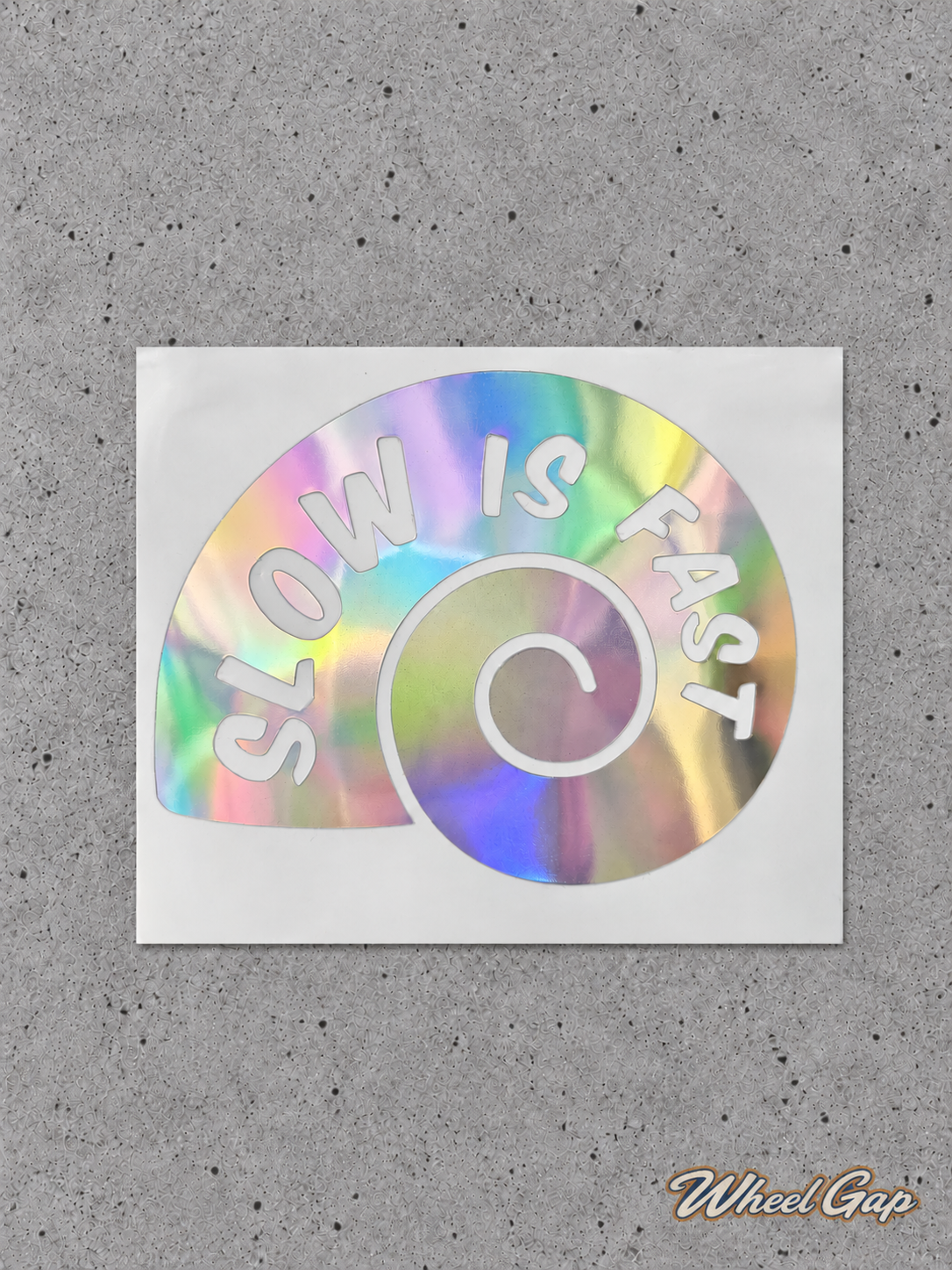 Slow Is Fast iridescent spiral car decal on grey concrete with Wheel Gap logo watermark