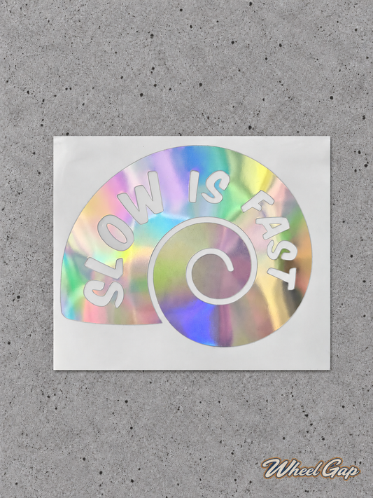 Slow Is Fast iridescent spiral car decal on grey concrete with Wheel Gap logo watermark